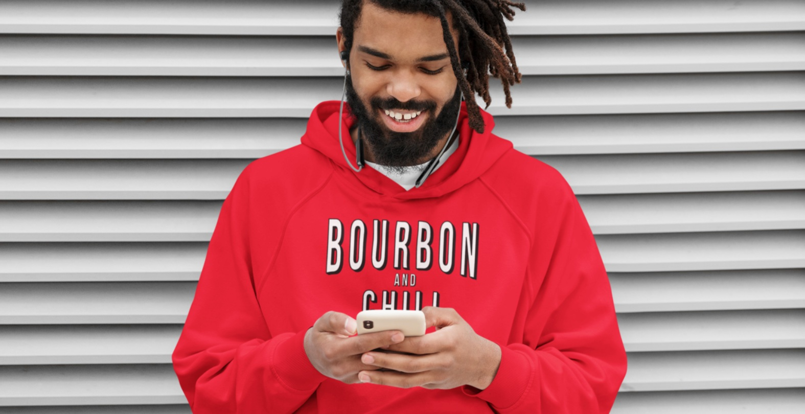 Bourbon and Chill Hoodie - Large/Red on man texting on cell phone leaning against a wall